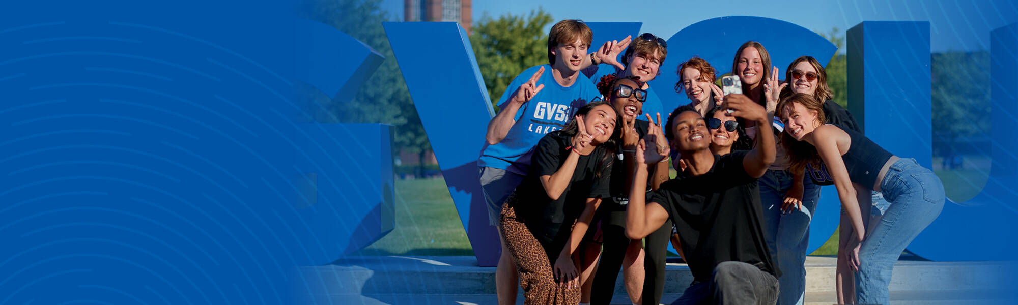 GVSU students in front of the blue letters.
